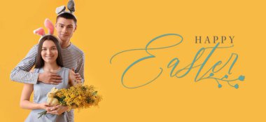 Easter banner with happy young couple in bunny ears on yellow background