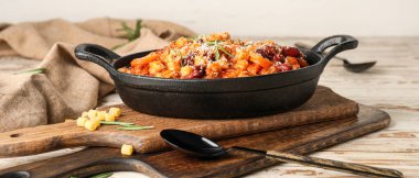 Dish with tasty pasta and beans on light table