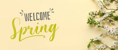 Beautiful blooming branches and text WELCOME, SPRING on beige background