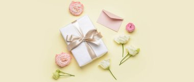 Composition with gift and flowers on yellow background. Women's Day celebration