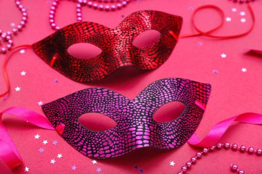Carnival masks with stars and beads on pink background, closeup