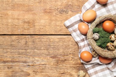 Nest with Easter eggs and moss on wooden background