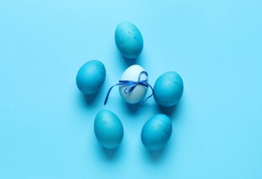 Composition with painted Easter eggs on blue background