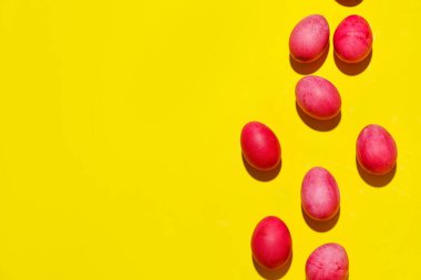 Composition with colorful Easter eggs on yellow background
