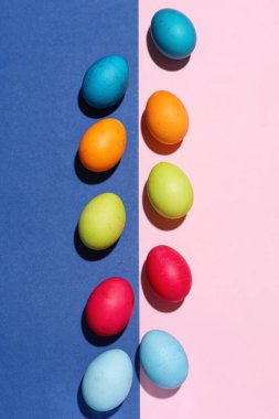 Composition with painted eggs for Easter celebration on color background
