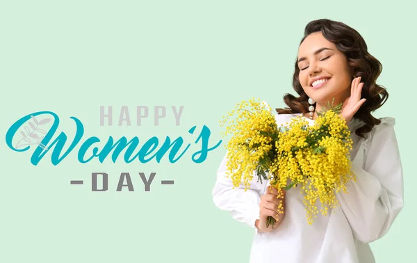Beautiful young woman with bouquet of mimosa flowers on light background. International Women\'s Day