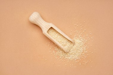 Wooden scoop with amaranth seeds on color background