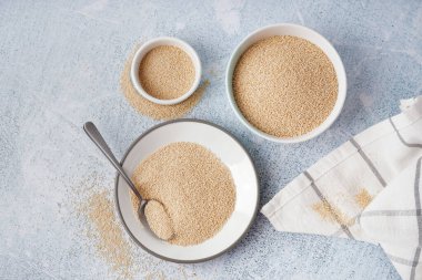 Bowls of amaranth seeds on light background