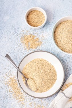 Bowls of amaranth seeds on light background