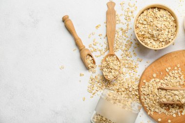 Composition with oatmeal flakes on light background