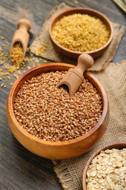 Bowl of buckwheat on dark wooden background, closeup