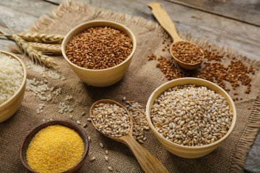 Bowls of different cereals on wooden table