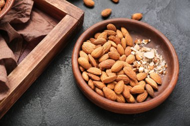Plate with almond nuts on dark background