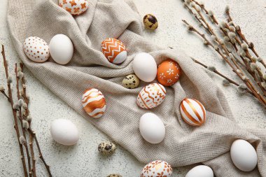 Composition with beautiful Easter eggs and willow branches on light background