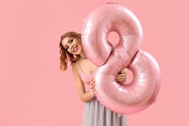 Happy young woman with balloon in shape of figure 8 on pink background. International Women's Day