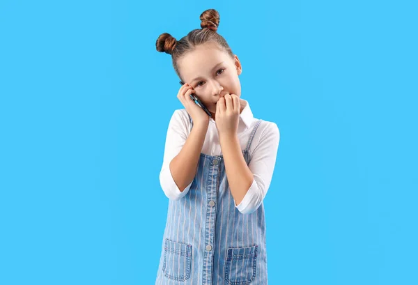 Little Girl Biting Nails While Talking Mobile Phone Blue Background — Stock Photo, Image