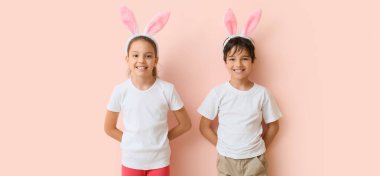 Happy little children with Easter bunny ears on pink background