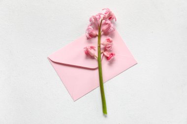 Envelope and beautiful hyacinth flower on light background