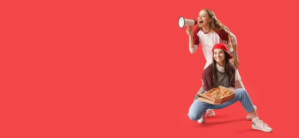 Young women with tasty pizza and megaphone on red background with space for text
