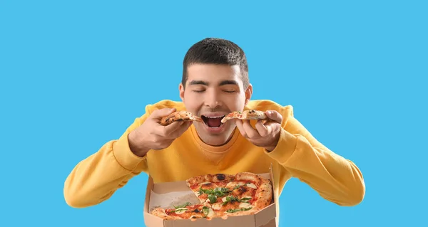 Hungry Young Man Eating Tasty Pizza Light Blue Background — Stock Photo, Image