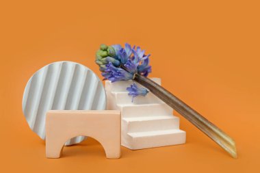 Podiums with beautiful flowers on orange background. Hello spring