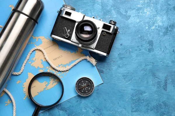 Compass with photo camera, magnifier and world map on grunge background