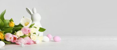 Flowers, Easter eggs and toy bunny on light background with space for text