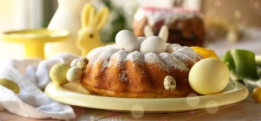 Plate with tasty Easter cake and eggs on wooden table
