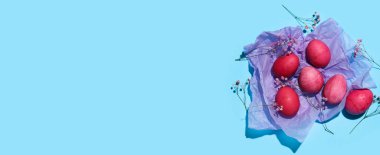 Festive composition with painted Easter eggs on blue background with space for text