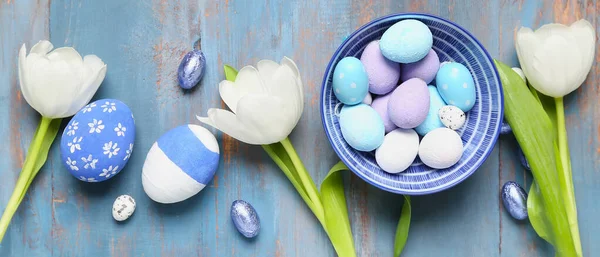 Összetétel Egy Tál Húsvéti Tojás Cukorka Tulipán Virágok Kék Háttér — Stock Fotó