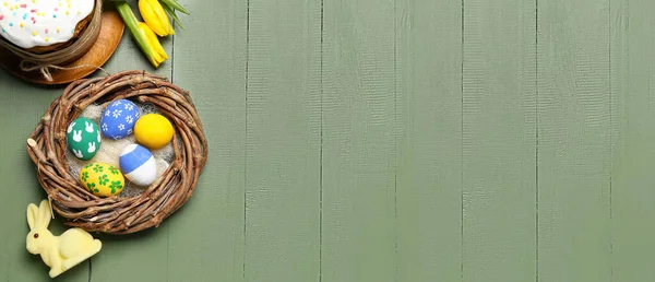 Nest Mit Bemalten Ostereiern Kuchen Und Häschen Auf Grünem Holzgrund — Stockfoto