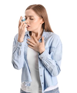 Sick young woman with inhaler on white background