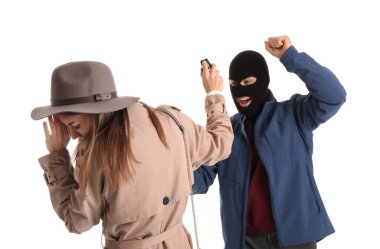 Young woman with pepper spray defending herself against thief on white background