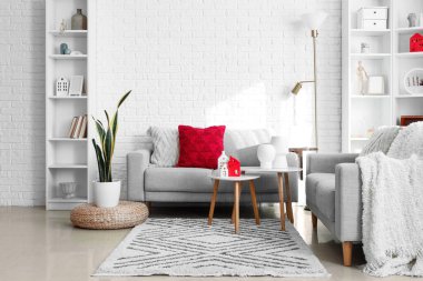 Interior of living room with sofas and house candle holders on table