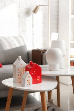 Glowing house candle holders on table in living room