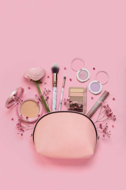 Composition with bag, cosmetics and flowers on pink background