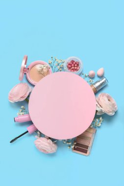 Composition with blank card, decorative cosmetics and flowers on color background