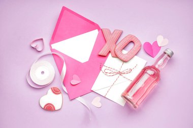 Composition with envelopes, sweet cookies, ribbon and bottle of drink on color background. Valentine's Day celebration