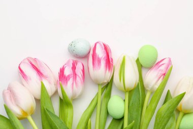 Beautiful tulip flowers and Easter eggs on white background, closeup