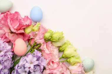 Composition with beautiful flowers and Easter eggs on white background, closeup