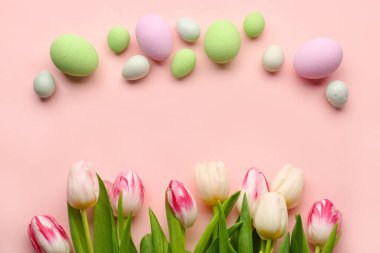 Composition with beautiful Easter eggs and tulip flowers on pink background