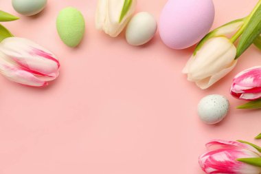 Composition with beautiful Easter eggs and tulip flowers on pink background, closeup