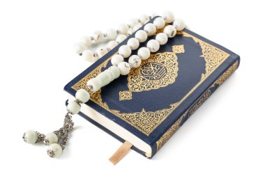 Koran with prayer beads for Ramadan on white background