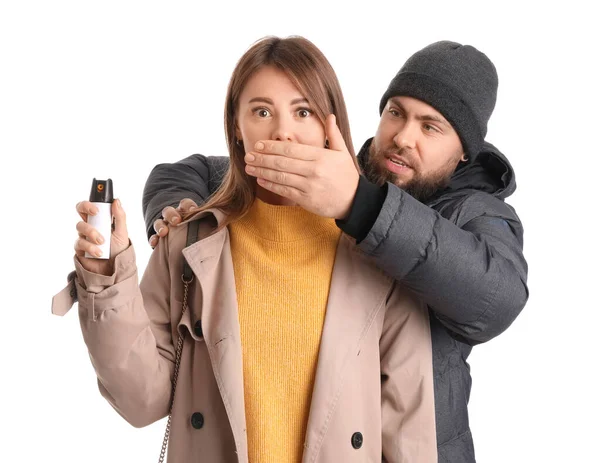 Thief shutting mouth of young woman with pepper spray for self-defence on white background