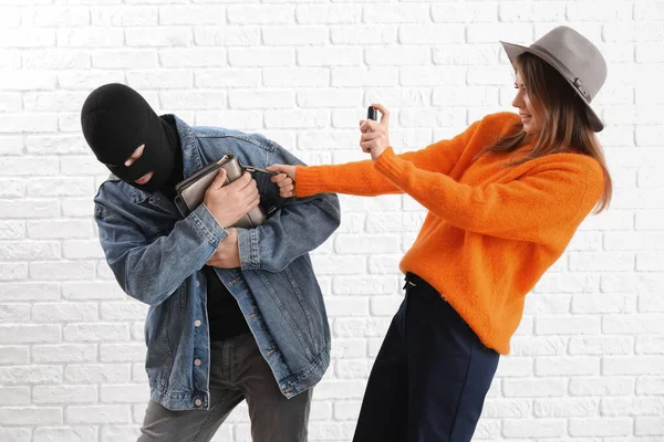 Young Woman Pepper Spray Defending Herself Thief White Brick Background — Stock Photo, Image