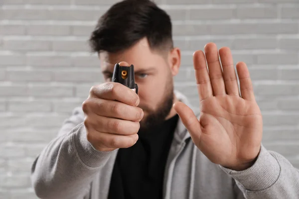 Young Man Pepper Spray Self Defence Showing Stop Gesture Grey — Stock Photo, Image