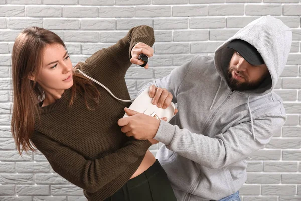 Young Woman Pepper Spray Defending Herself Thief Grey Brick Background — Stock Photo, Image
