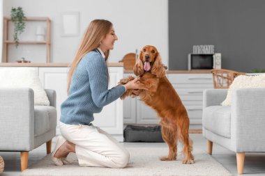 Young woman with red cocker spaniel in kitchen