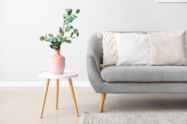 Interior of modern living room with soft pillows on grey sofa