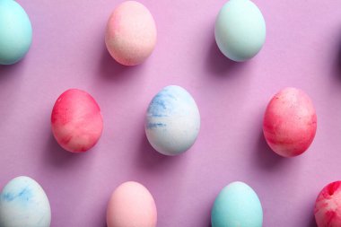 Composition with painted Easter eggs on lilac background